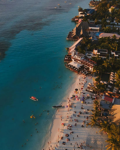 Nungwi Beach Zanzibar with turquoise water, beach resort and tourists swimming on the north coast