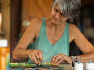 Christine Andrieu, art-thérapeute à La Réunion, peignant aux encres avec les doigts dans son atelier