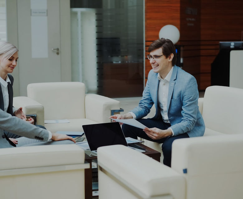 Three business people in a modern office meeting.
