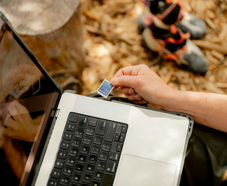 A person holding a laptop computer in their hands