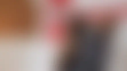 A veterinarian holds a black and brown dog in his arms