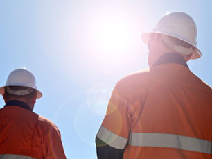 Two builders looking at the sun