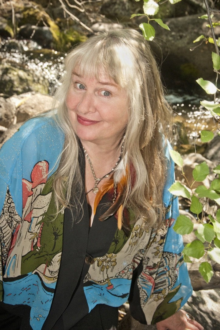 Smiling woman in colorful clothing poses near foliage, Conscious Leadership Institute.