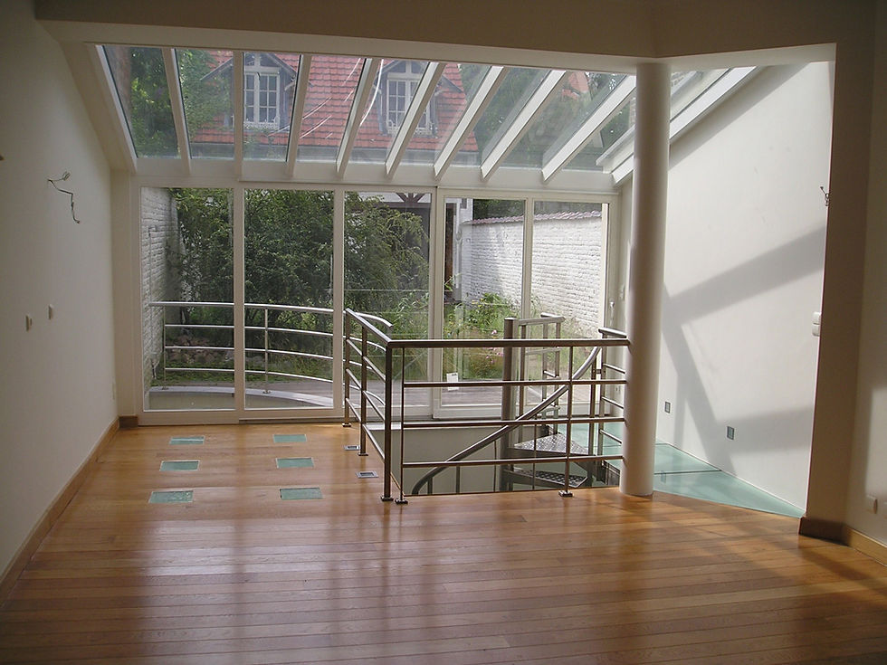 Intérieur lumineux avec parquet, verrière et escalier métallique après rénovation Belgimm I