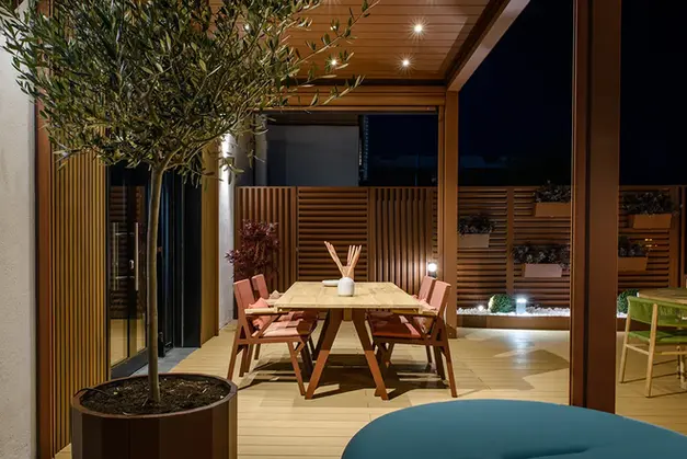 Terrasse am Abend mit Terrassenüberdachung und Sichtschutzelement