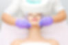 Model on treatment table receiving facial treatment.