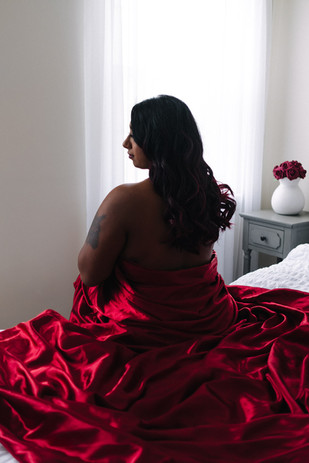 Woman looking out window during her luxury boudoir photoshoot in Maryland
