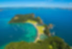 Aerial view showcasing the stunning Bay of Islands in New Zealand, featuring turquoise waters and lush green islands.