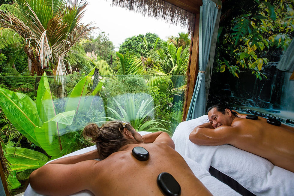 Thumbnail: Two individuals relaxing on a massage table, with smooth hot stones placed on their backs for therapeutic treatment.
