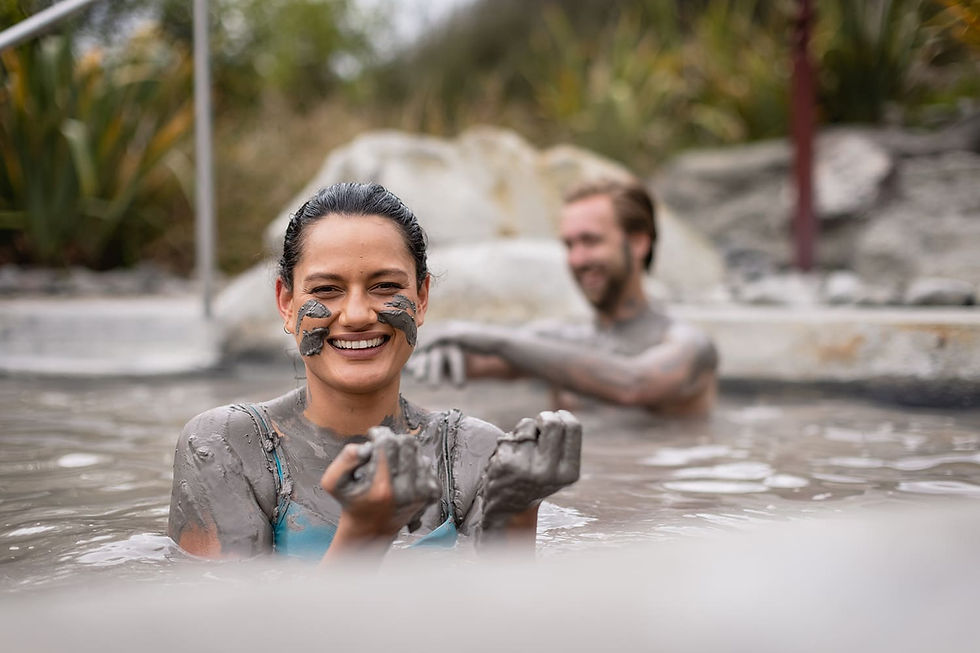 Thumbnail: A couple relaxes in a hot tub, playfully covered in Rotorua mud masks, enjoying a moment of leisure and fun together.