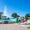Thumbnail: A group of five people walk along a path near a large fountain with water spraying up, enjoying the top attractions.