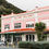 Thumbnail: A pink and white building labeled HOLTOMS BUILDINGS 1920 stands on a street in Paekakariki, hinting at a café break.