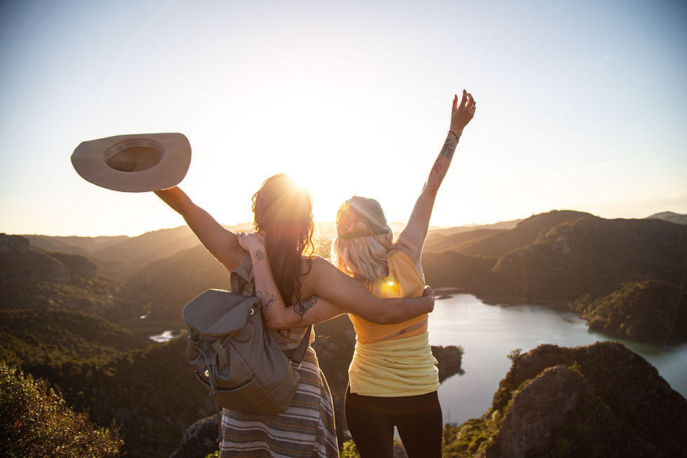 Thumbnail: Two women joyfully raise their arms in the air, celebrating a moment of happiness and unity above Whangaroa Harbour, NZ