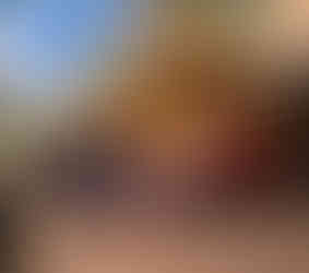 A family of four is strolling down a city street in Christchurch, New Zealand, with a vintage tram in the background.