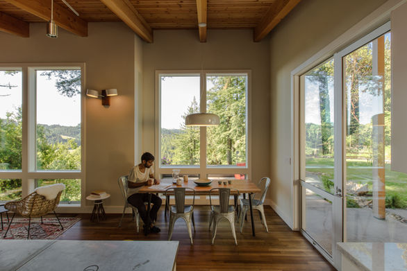 Cazadero House expansive great room and dining space with a wood-burning fireplace reaches out to the views and invites everyone to sit and enjoy.