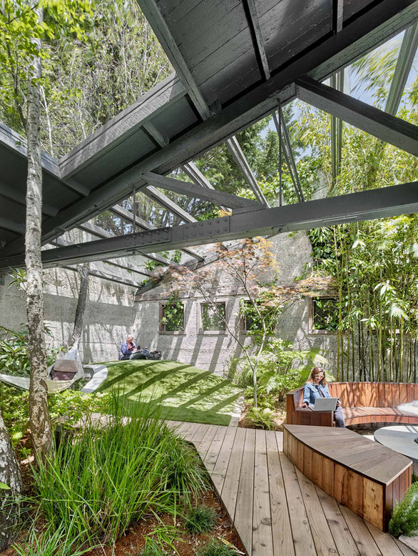 Humangear HQ open air space transformed into a magical modern oasis with casual work spaces and park-like with varied areas of landscaping.
