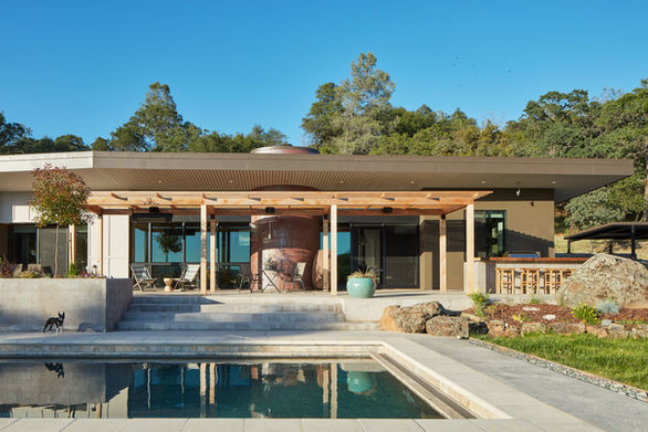 Auburn House, large linear patio connecting two wings with outdoor lounge areas, garden beds, cedar trellis and 75-foot lap pool. 