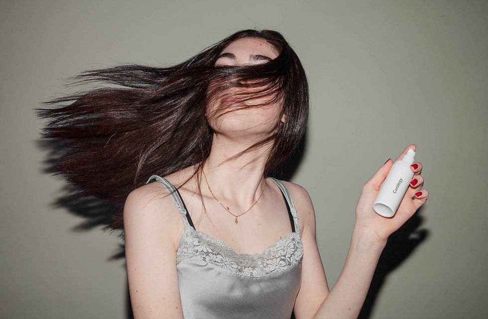 brunette with long hair holding a hair spray