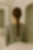 Woman with a braid, back to camera, in a tiled white bathroom wearing a gray top. Mood is calm; sink and mirror visible.