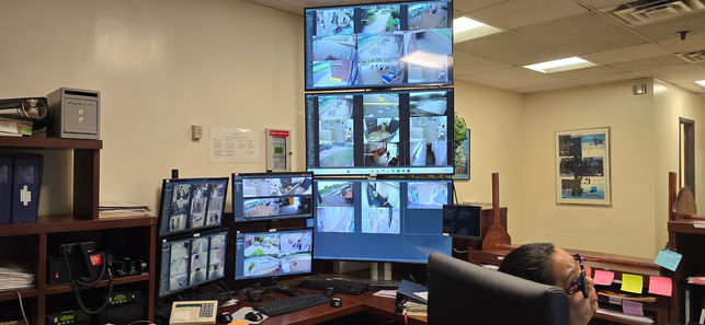 Multiple monitors displaying CCTV footage in security control room environment, monitoring CCTV.