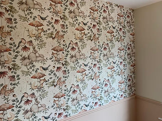 Wallpaper with whimsical woodland design featuring rabbits, squirrels, birds, and mushrooms in soft earthy tones