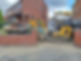 Excavator near brick wall