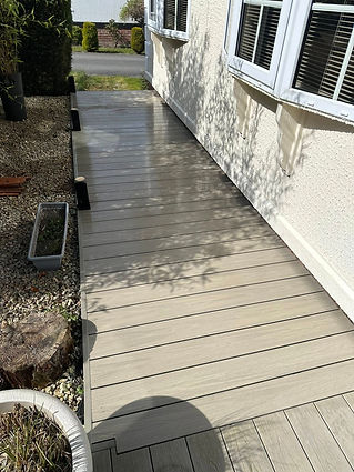 A deck with a white fence surrounding it and a white door visible.