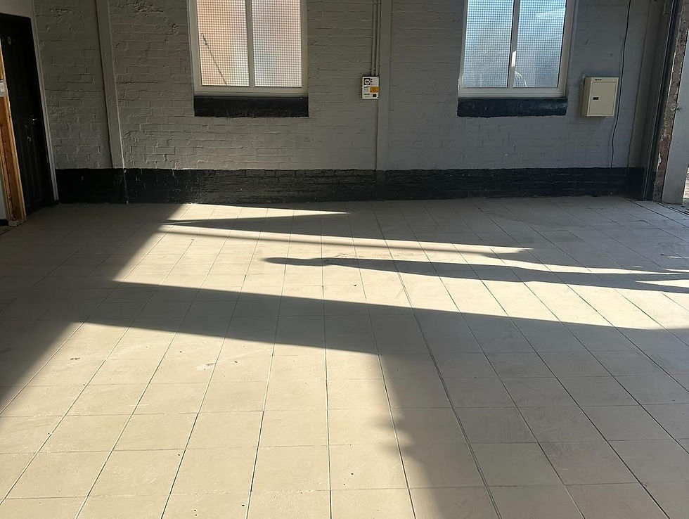 Sunlight streams through a window, casting long, geometric shadows on a tiled floor