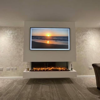 Modern living room with a wall-mounted TV displaying a beach sunset. Below, a sleek fireplace emits a warm glow