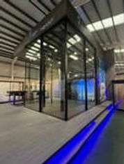 A glass-enclosed room illuminated by blue lights