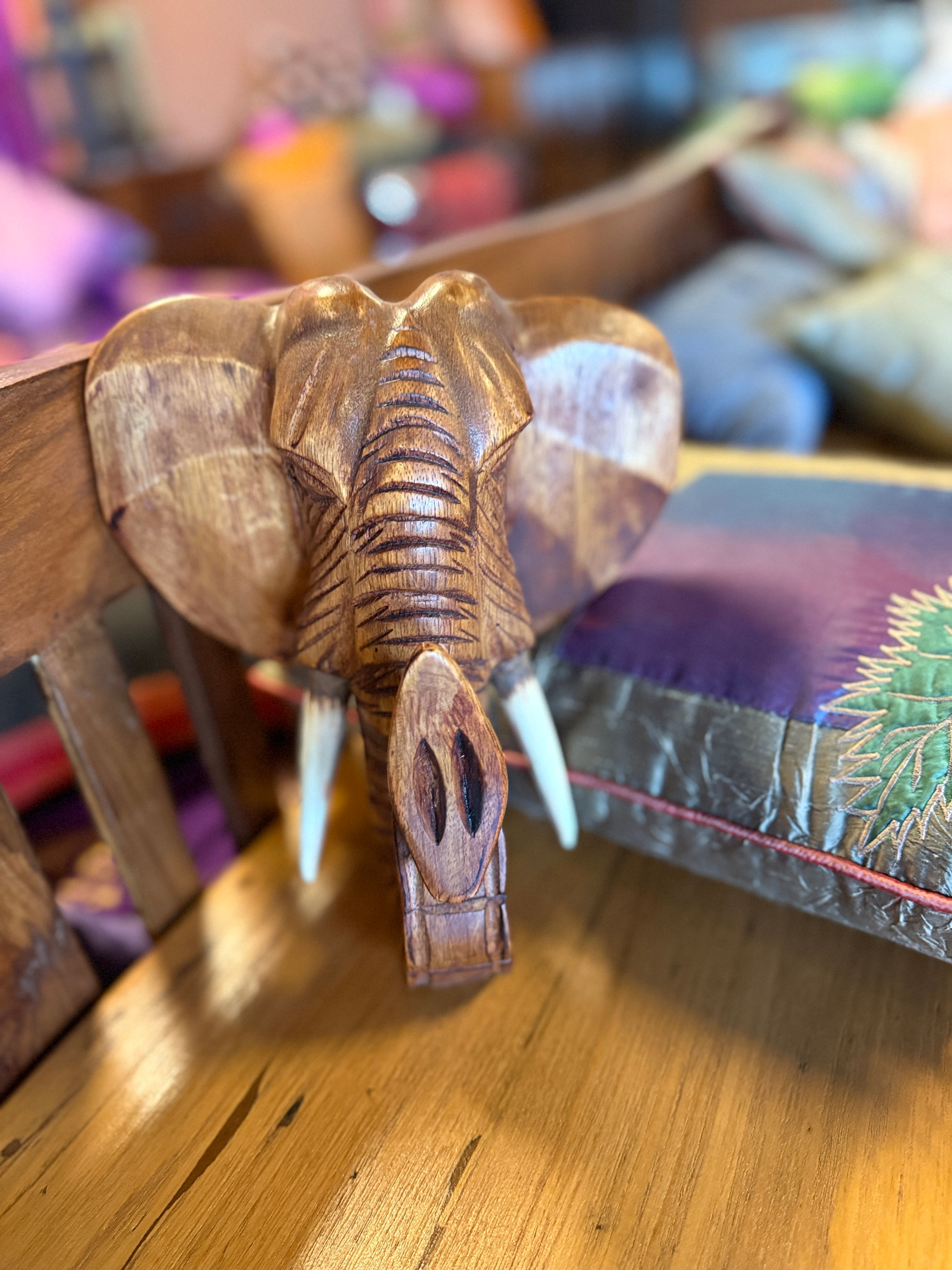Handcrafted wooden elephant head wall decor with intricate carvings and natural wood finish
