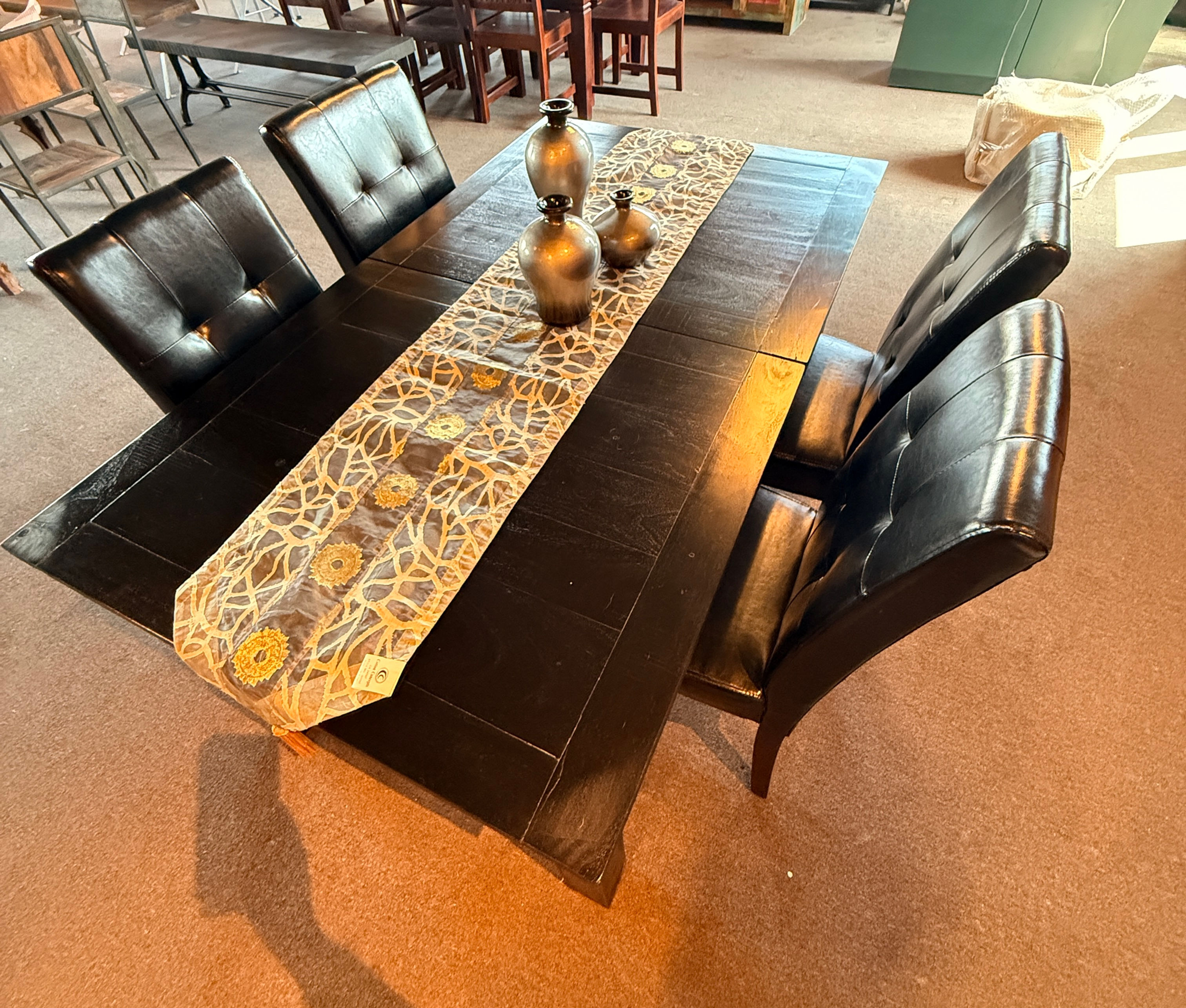 Dark brown solid wood butterfly extension dining table set with four matching chairs in a cozy dining area.
