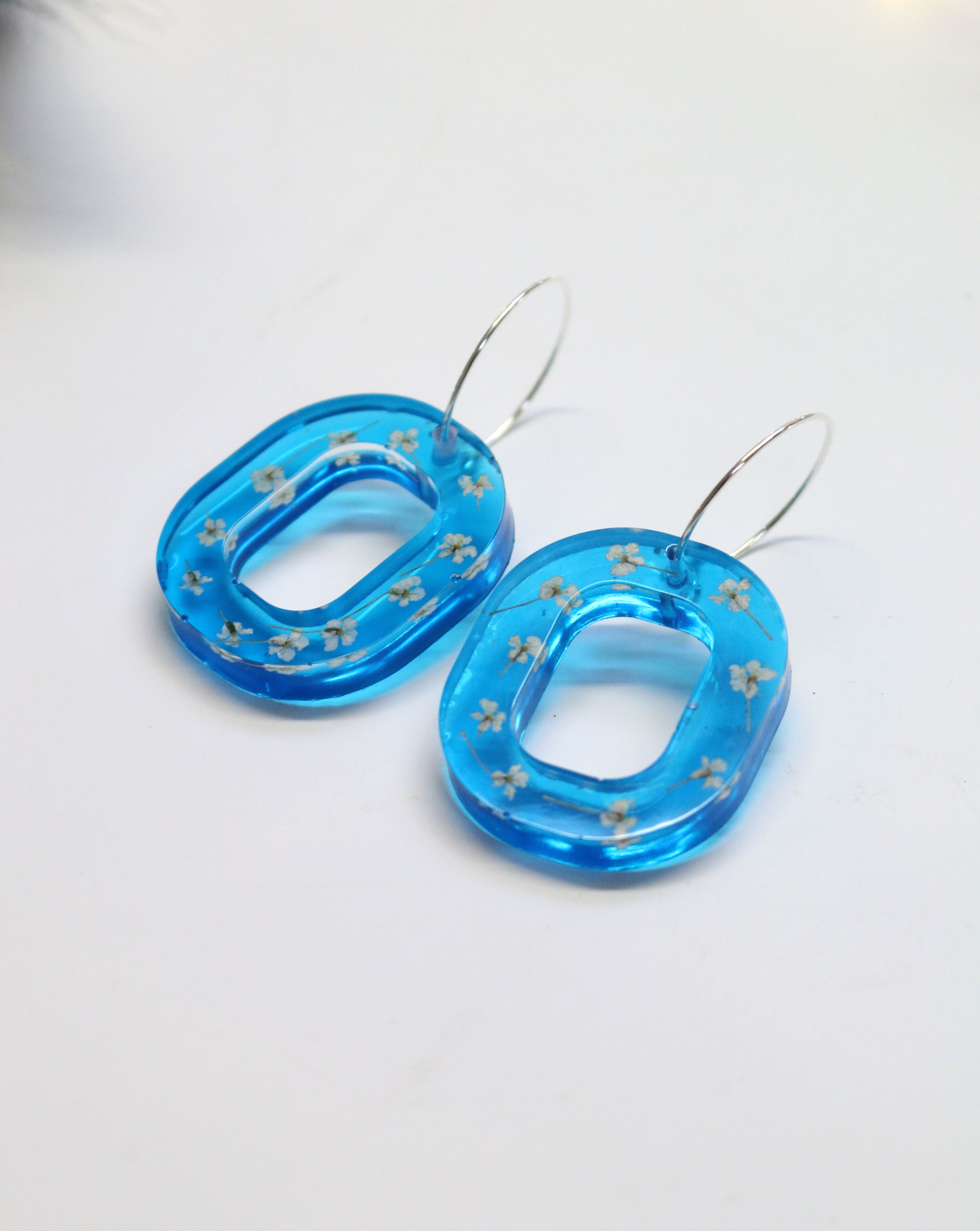 Translucent blue hoop earrings with white flower 'snowflakes'