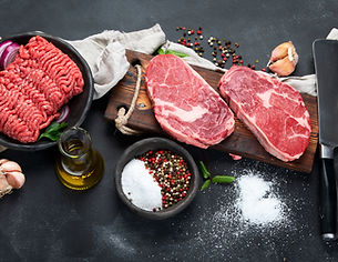 Variety of raw meat with seasoning on dark background. Top view, panorama, banner.jpg