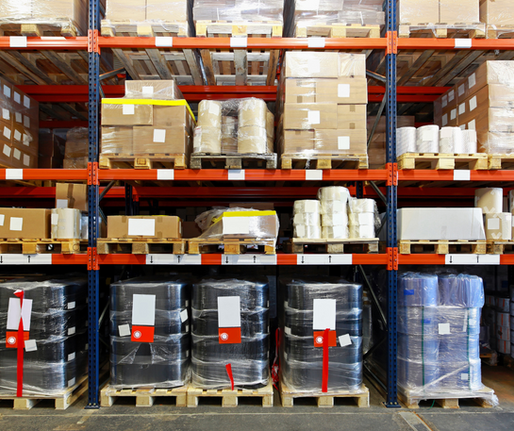 Warehouse wall lined with stacked pallets and organized storage, showcasing industrial efficiency.