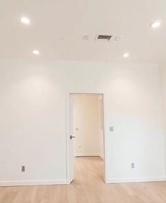 Intérieur rénové avec murs blancs lisses, éclairage encastré et finition moderne prête à aménager