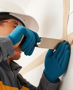 Découpe précise de plaque de plâtre par un plaquiste pour ajustement des cloisons sèches