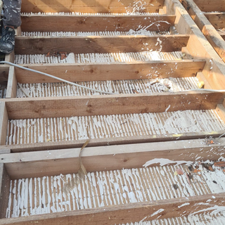 Charpente en bois en cours de rénovation avec isolation apparente, travaux de structure réalisés par un charpentier professionnel