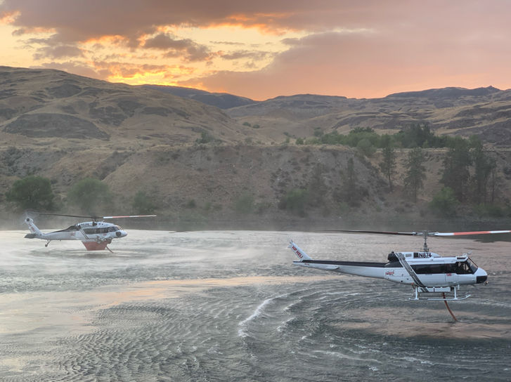 Double Dip.  HP fleet of UH-1Hs and HP-60s hover filling with snorkels at twilight to battle the fires in the Northwestern U.S.  Our 1,100 gallon external tank made serveral drops every hour to help contain the fires.