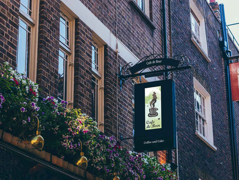 Pub sign, flowers, and brick building