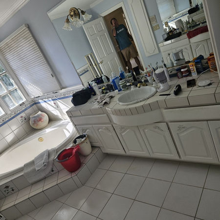 Original primary bathroom with white tile and dated cabinetry before interior redesign in Costa Mesa