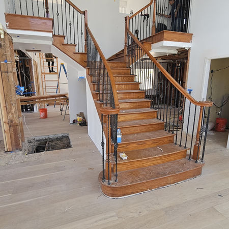 The original staircase — warm wood tones and traditional iron balusters. A solid foundation, but no longer aligned with the direction the clients wanted to take the home.