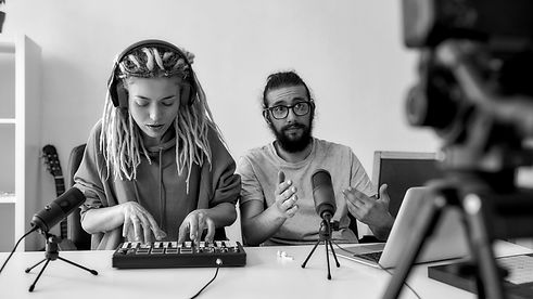 Woman playing keyboard sitting next to man with microphone