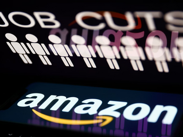 Attendees walking past a large wooden wall displaying the Amazon Web Services (AWS) logo at a corporate event.