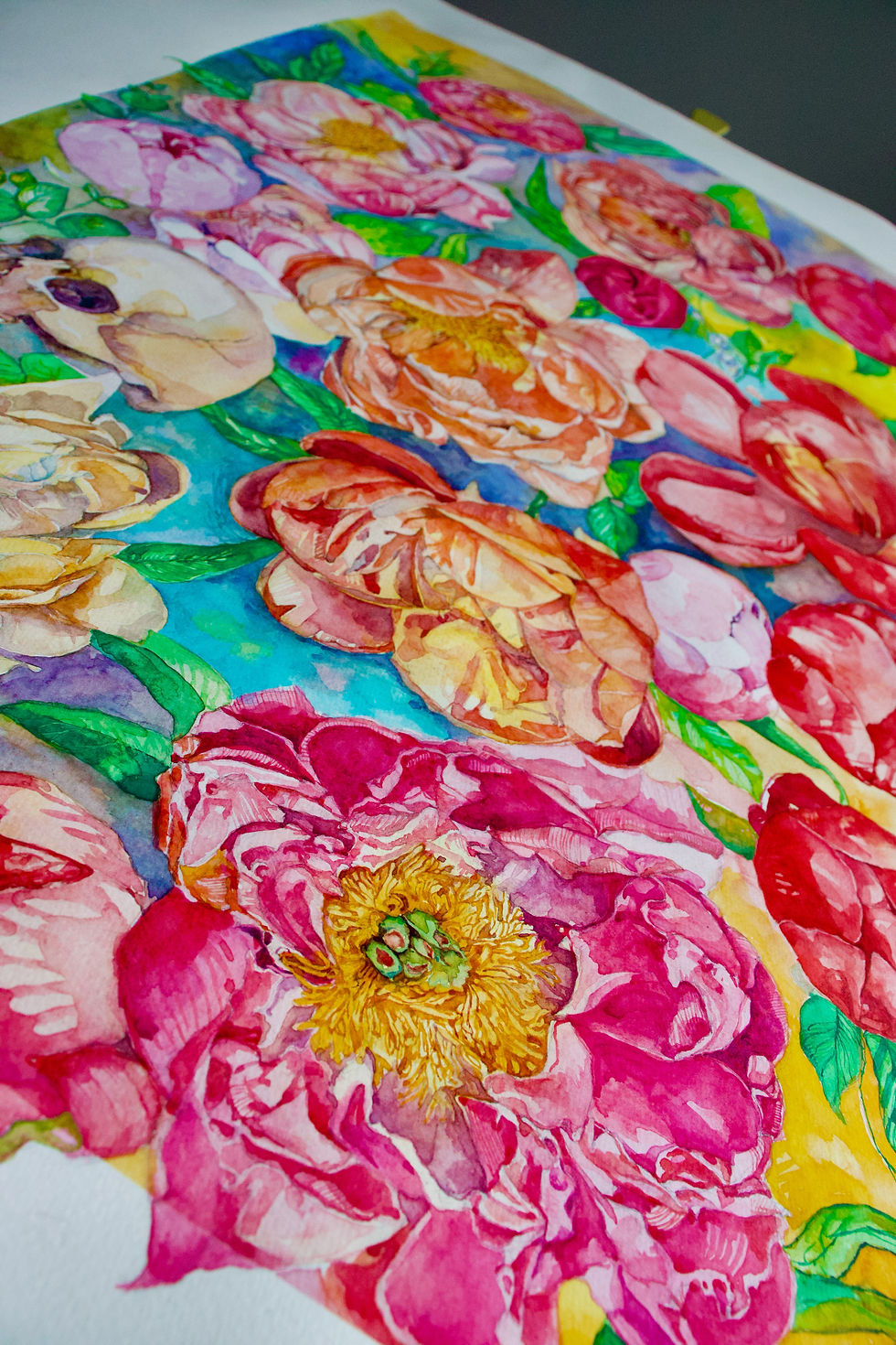 Close-up view of watercolor painting blending human anatomy with blooming flowers