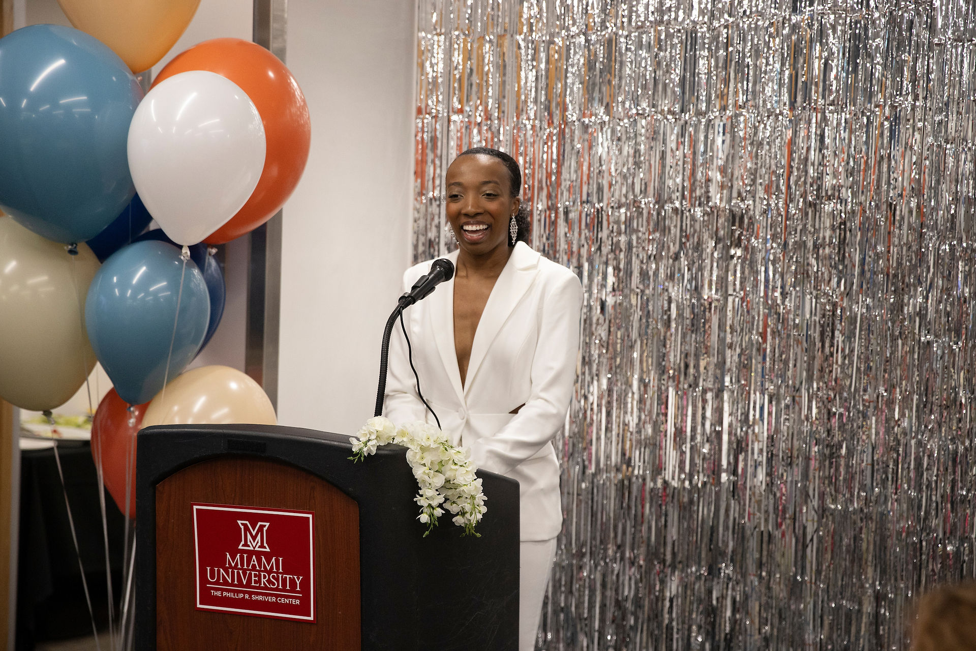 woman in white suit standing at a podium