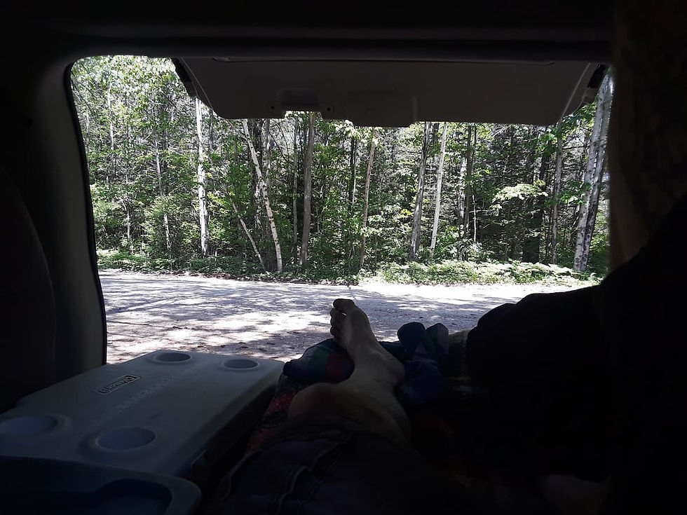 looking out the back hatch of a van past my toes t some trees