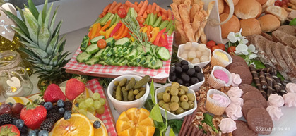 Grazing table showing the crudite board surrounded by olives and pickles