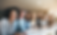 Business people sitting in a line smiling at the camera