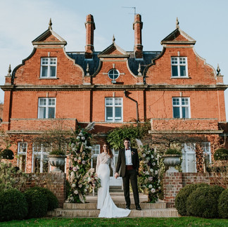 Wedding couple pose outside Chippenham Hall